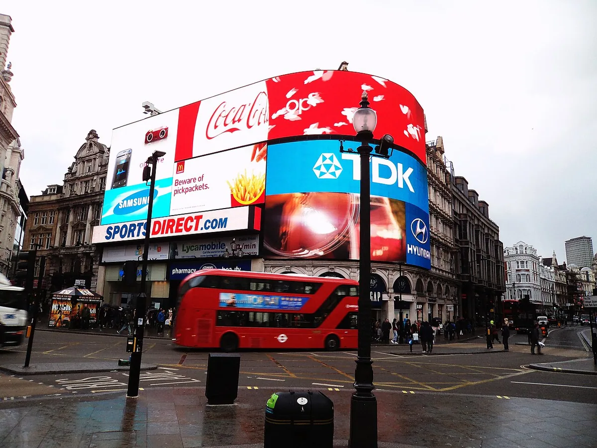An unidentified New Routemaster , one of the route 38 trial buses based on the livery, passes through Picadilly Circus.